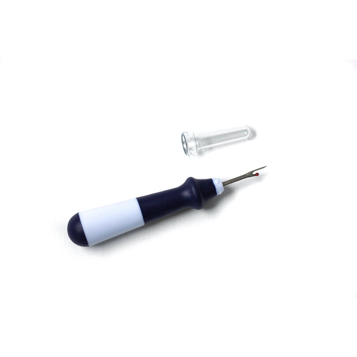 Navy blue seam ripper shown with needlepoint canvas